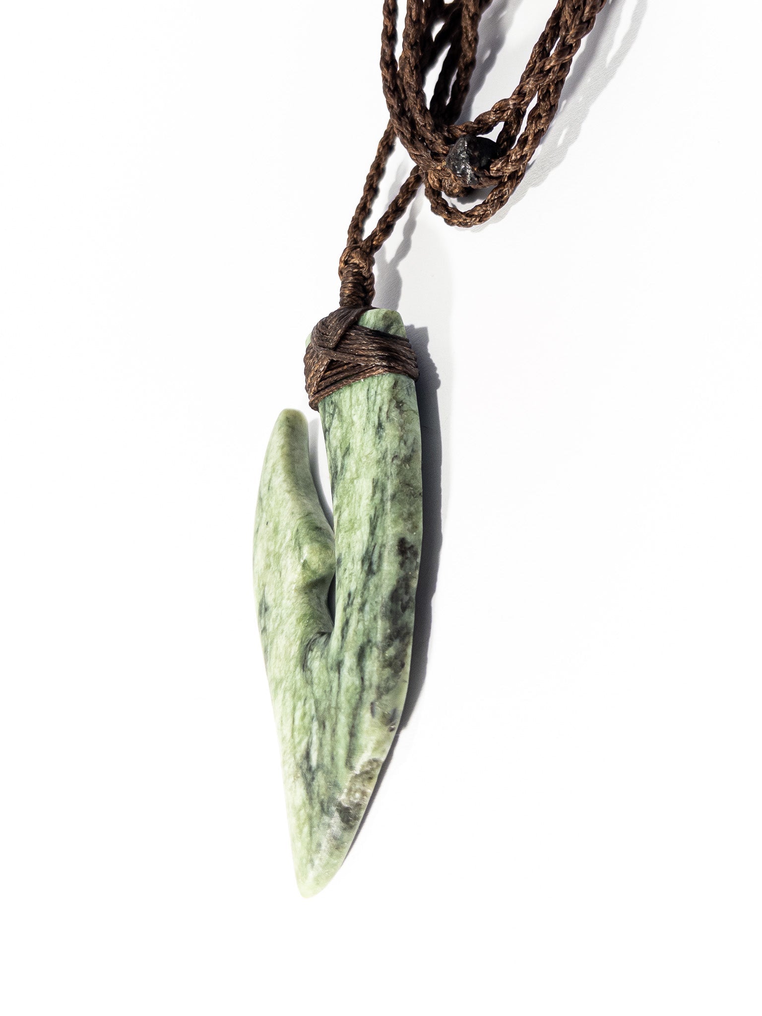Pounamu Fishhook on plain background