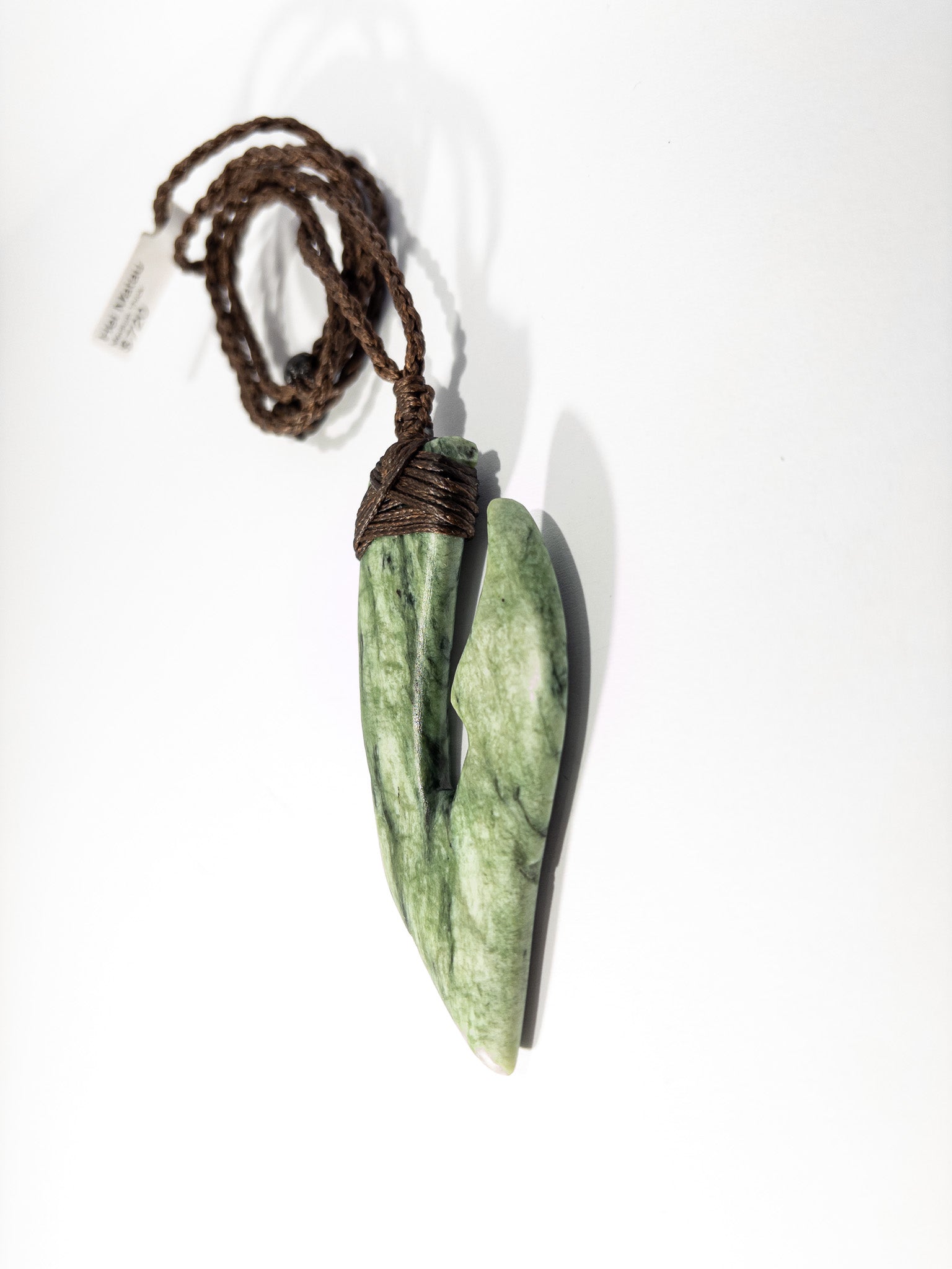 Pounamu Fishhook on plain background
