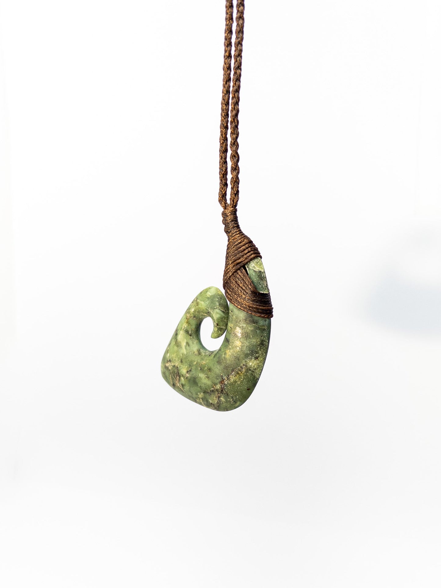 Pounamu Fishhook on plain background