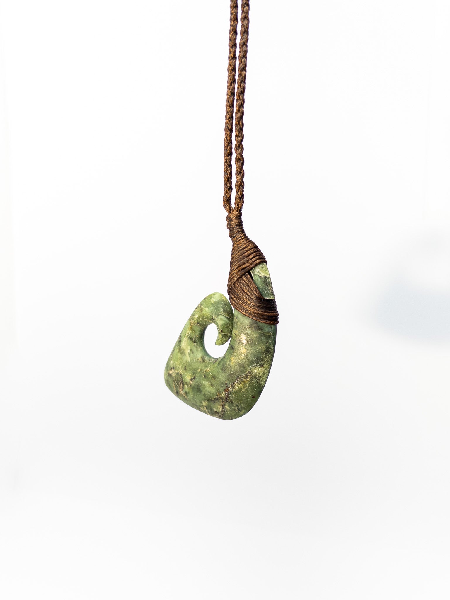 Pounamu Fishhook on plain background