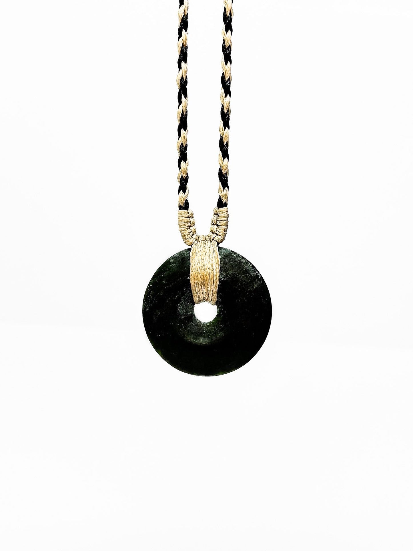 Circle of Life or Porowhita pounamu twist pendant on Black background