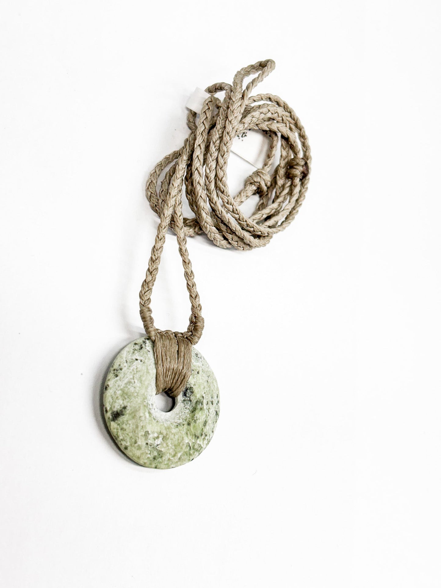 Circle of Life or Porowhita pounamu twist pendant on Black background