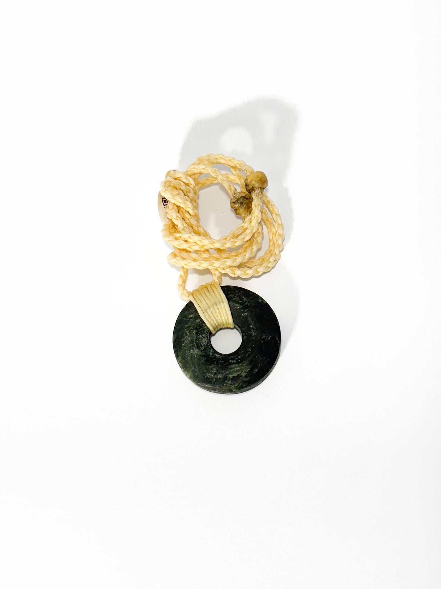 Circle of Life or Porowhita pounamu twist pendant on Black background