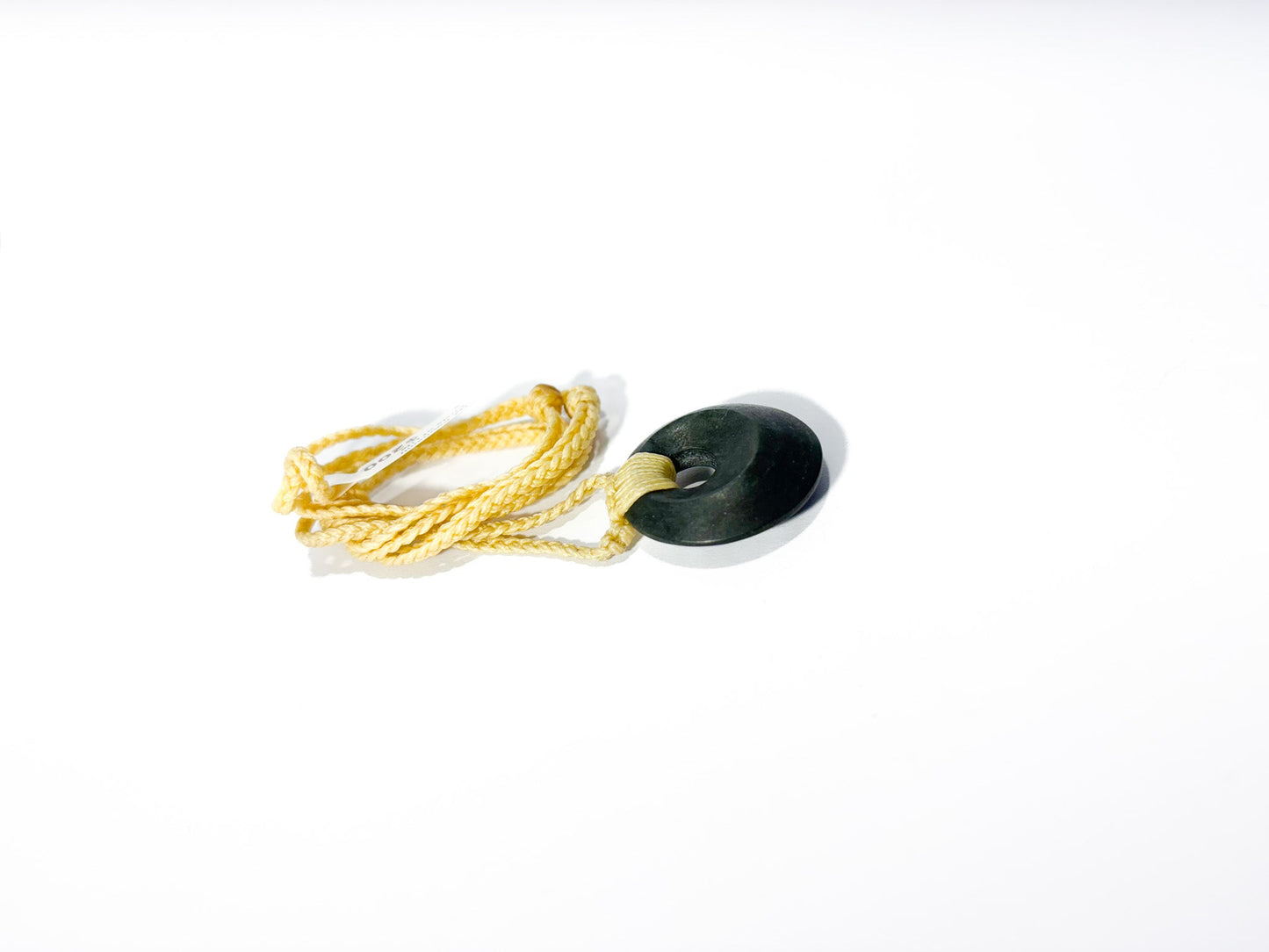 Circle of Life or Porowhita pounamu twist pendant on Black background