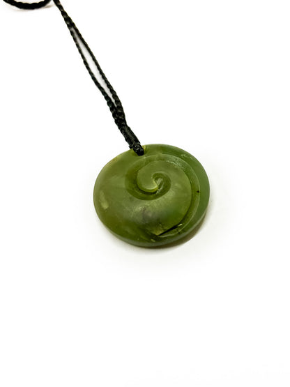 Diagonal angle Pounamu koru pendant on white background